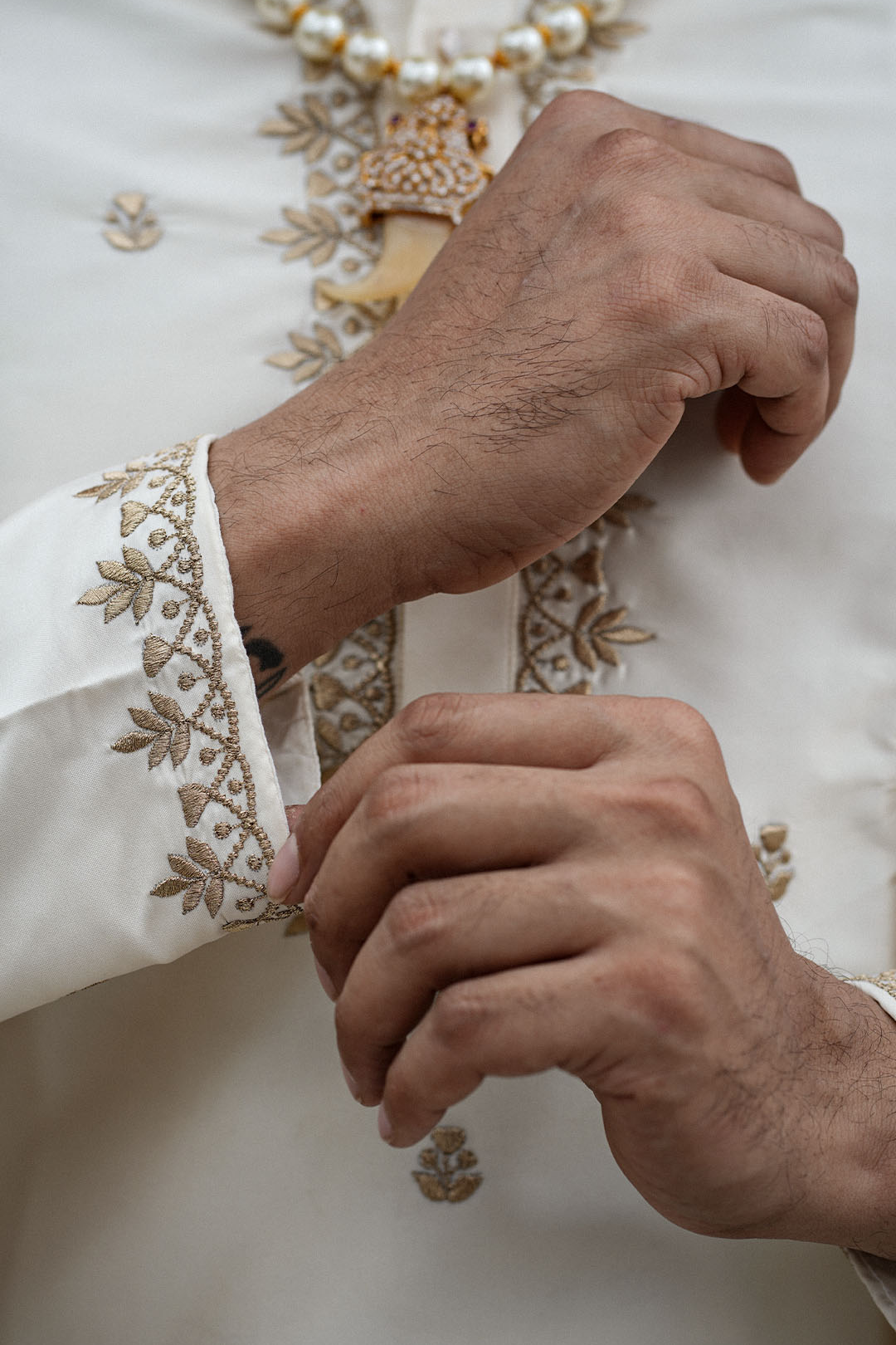 Close-up of hands with embroidered cuffs on a garment
