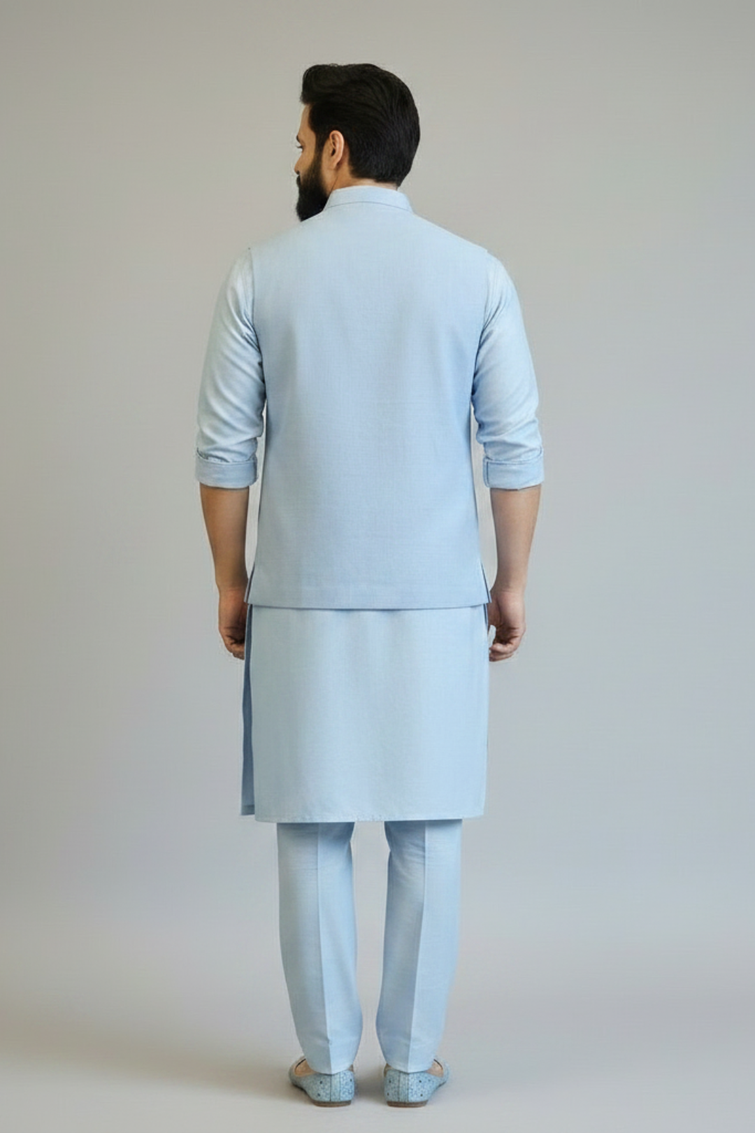 Man wearing a light blue kurta set against a plain background