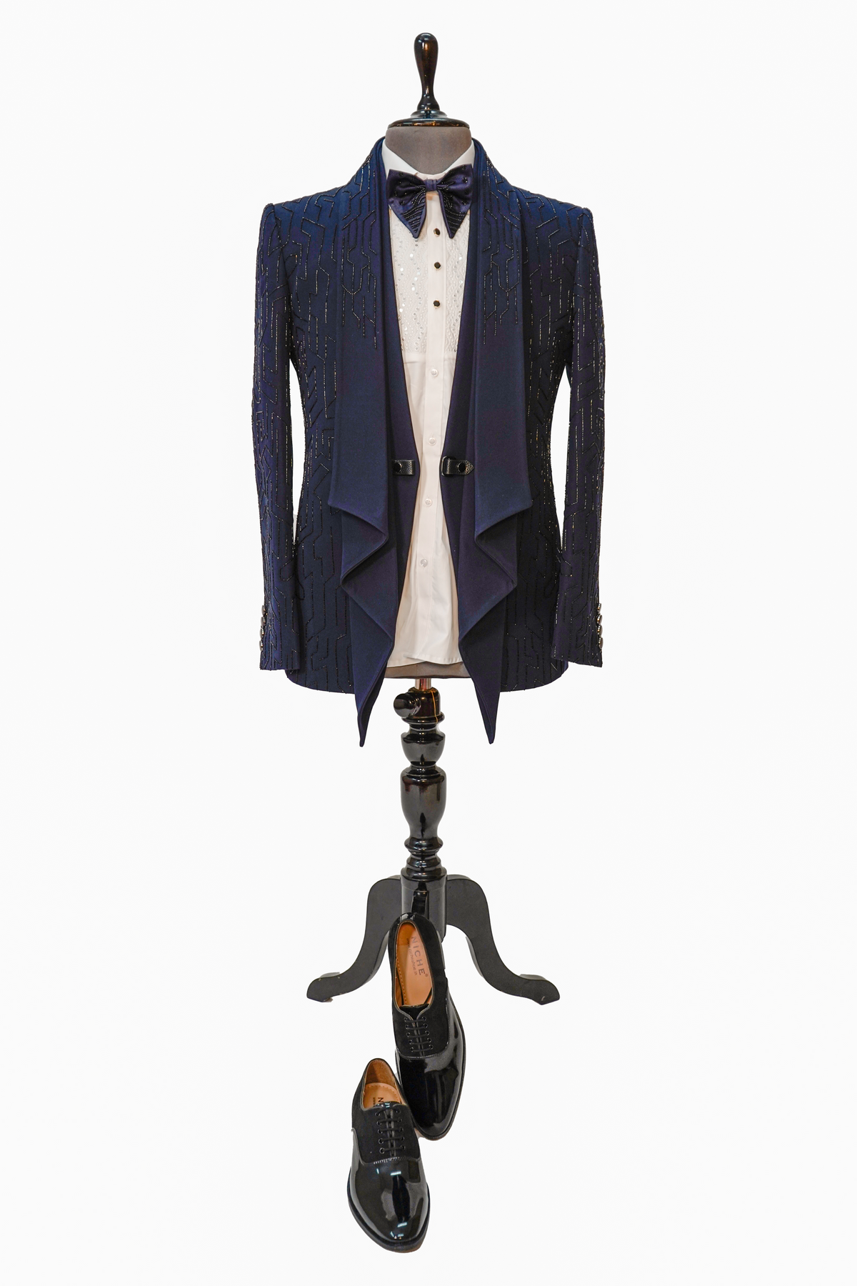A Midnight Blue 5-Piece Designer Tuxedo displayed on a mannequin, consisting of a blue woolcrepe jacket, white vest, white shirt, blue bow tie, and blue trousers.