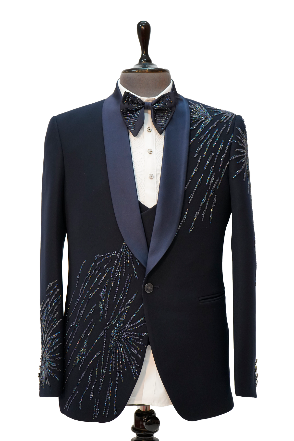 A navy blue tuxedo with vibrant colored curtdana embroidery displayed on a mannequin.