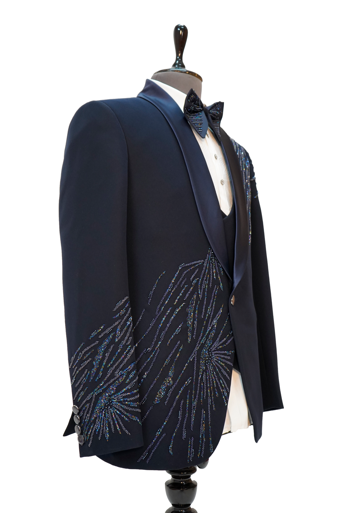 A navy blue tuxedo with vibrant colored curtdana embroidery displayed on a mannequin.
