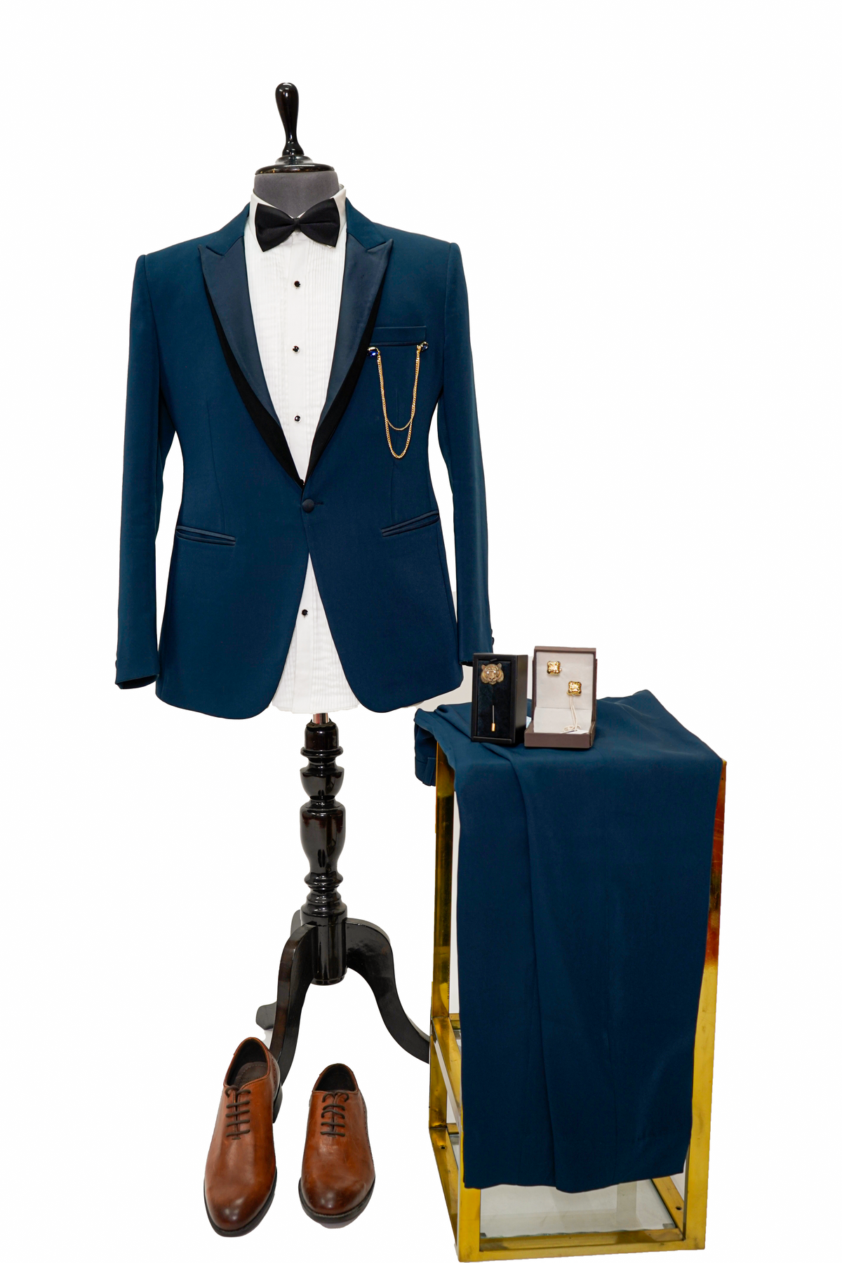 Man in a teal suit sitting on a wooden stool against a plain background
