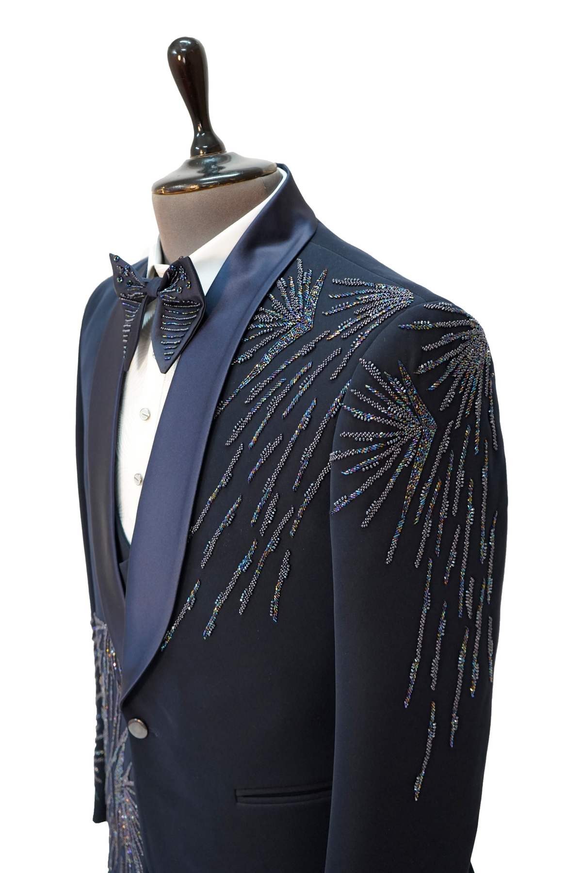 A navy blue tuxedo with vibrant colored curtdana embroidery displayed on a mannequin.