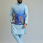 Man wearing a light blue traditional outfit with embroidered vest on a plain background