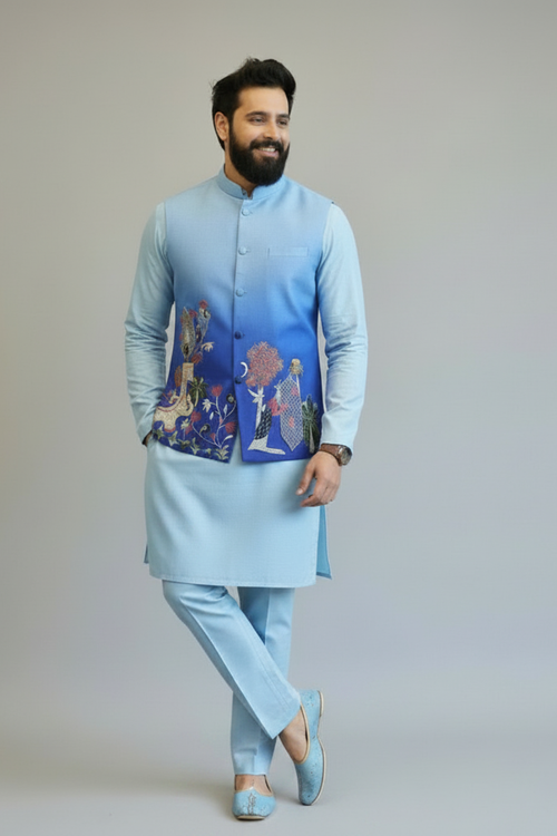 Man wearing a light blue traditional outfit with embroidered vest on a plain background