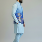 Man wearing a light blue traditional outfit with an embroidered vest on a plain background