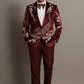 Man wearing a burgundy suit with intricate patterns against a plain background