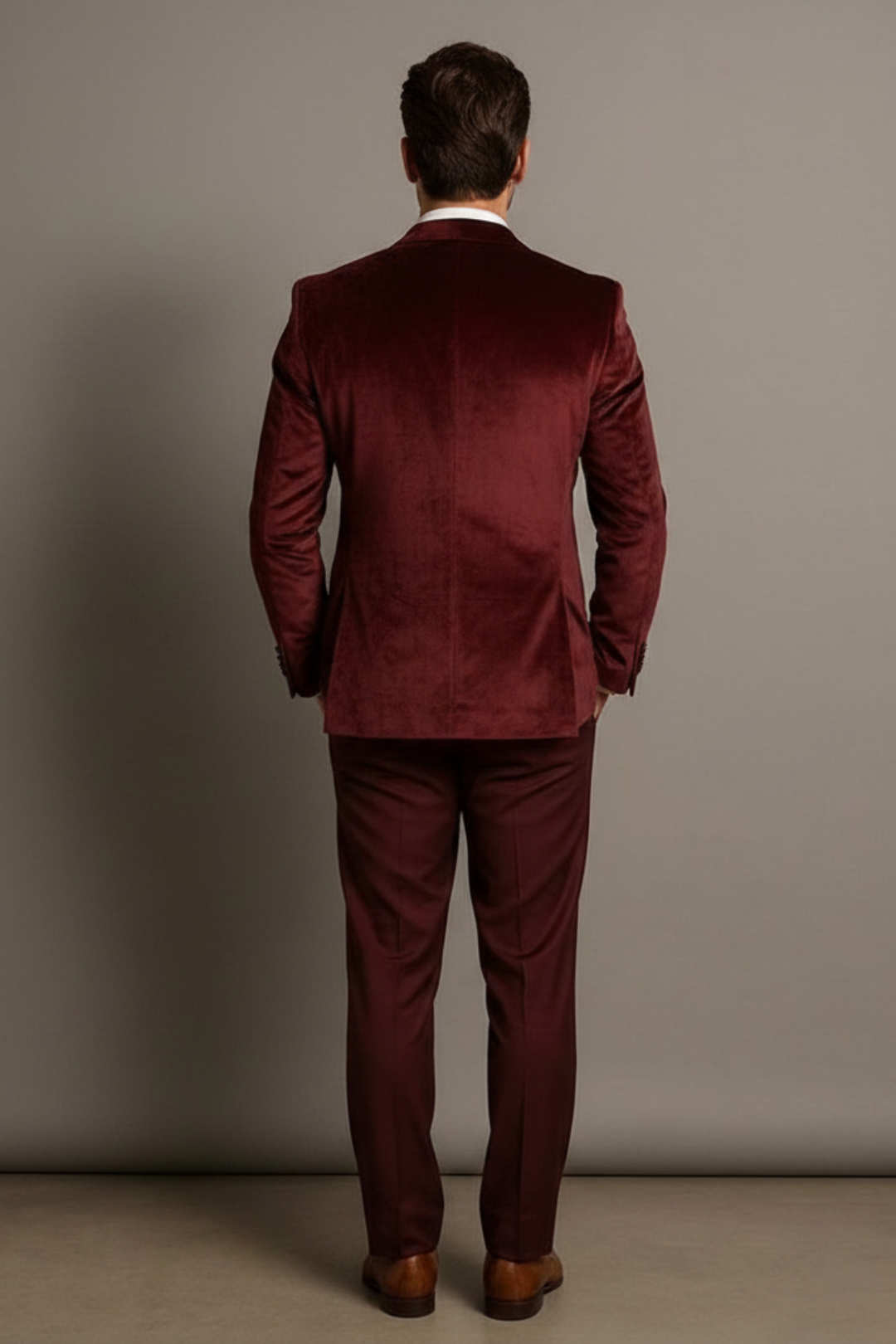 Man wearing a burgundy velvet suit against a plain background