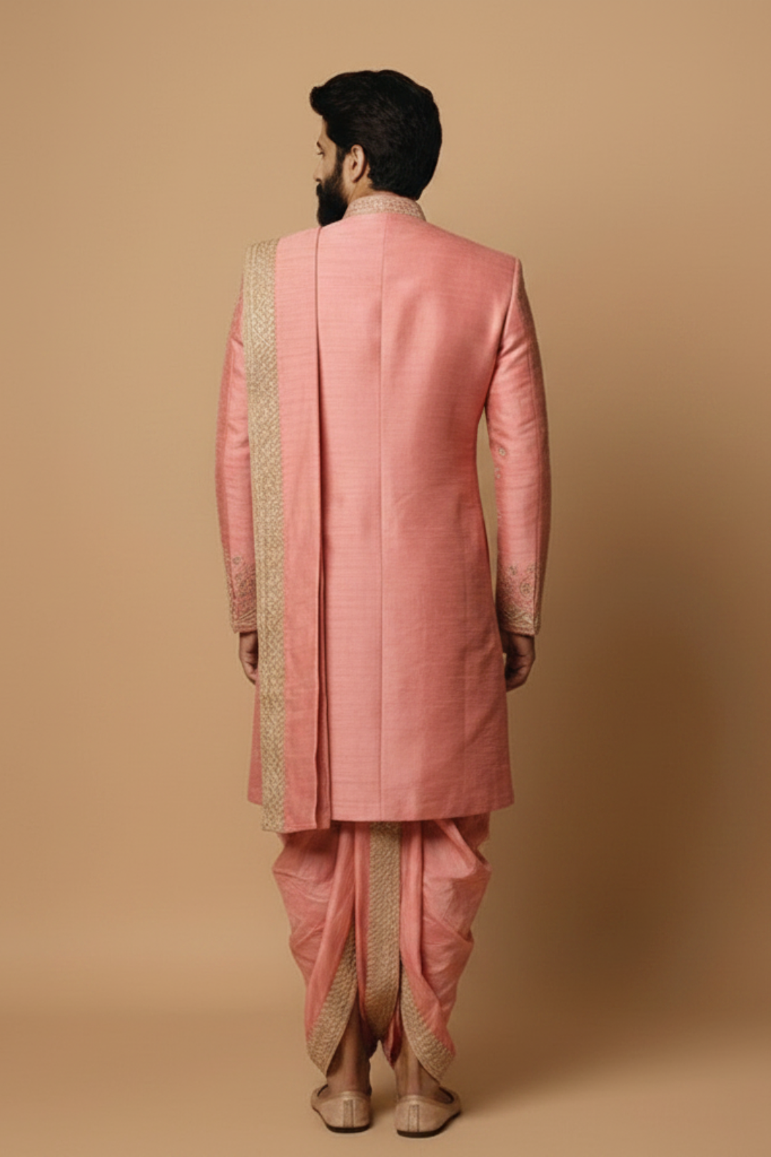 Man wearing a pink sherwani with a beige background