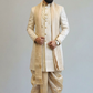 Man wearing a traditional beige sherwani with a plain background