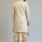 Man wearing a beige traditional outfit with a dhoti on a plain background