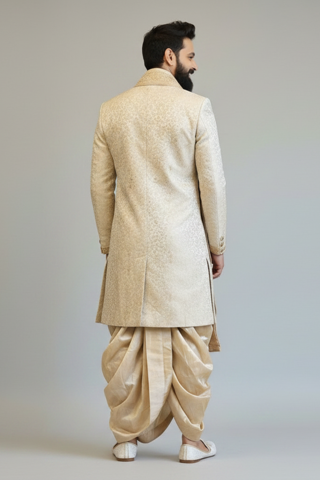 Man wearing a beige traditional outfit with a dhoti on a plain background