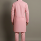 Man wearing a pink kurta with pants against a gray background