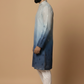 Man wearing a blue and white gradient kurta with white pants on a beige background