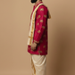 Man wearing a red sherwani with gold patterns on a beige background