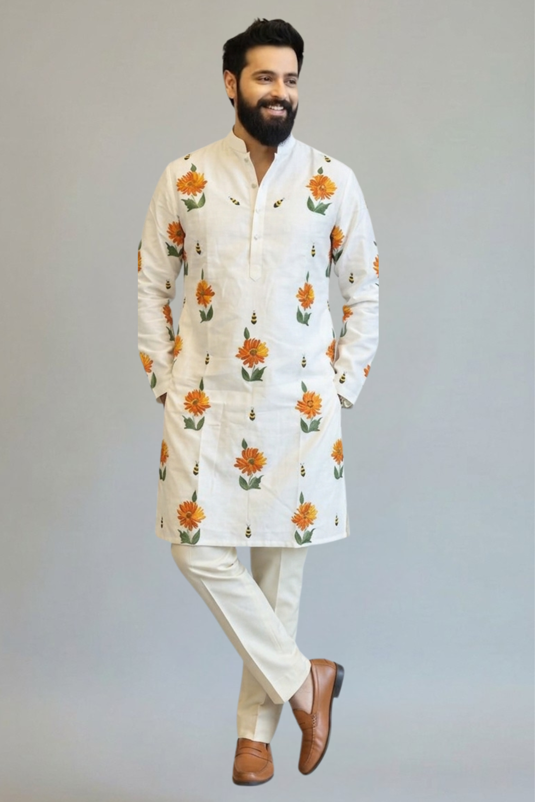 Man wearing a white kurta with floral patterns on a plain background
