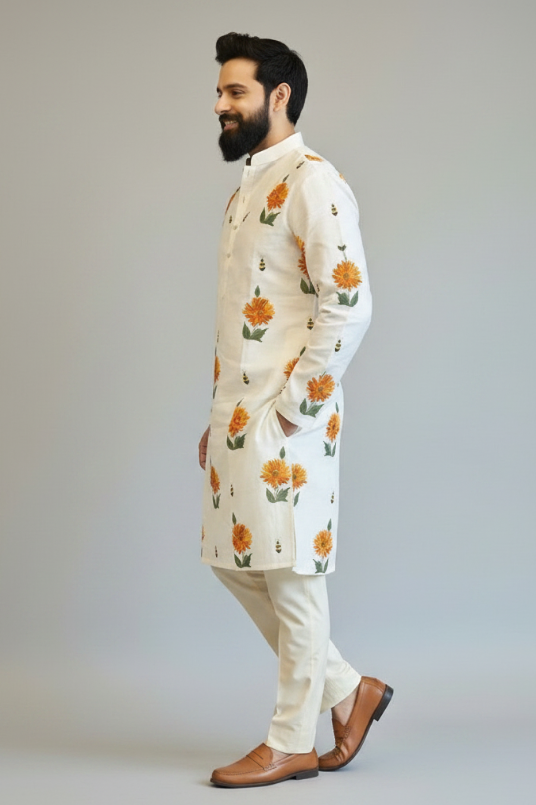 Man wearing a white kurta with floral patterns on a plain background