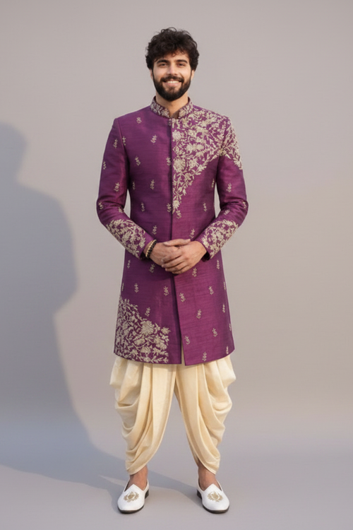 Man wearing a purple embroidered sherwani with white pants on a gray background