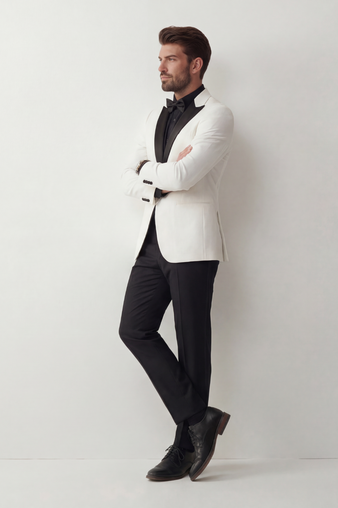 Man wearing a white tuxedo with black pants and shoes against a white background