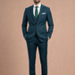 Man wearing a dark green suit with a white shirt and green tie against a beige background