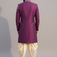 Man wearing a purple sherwani with white dhoti on a plain background