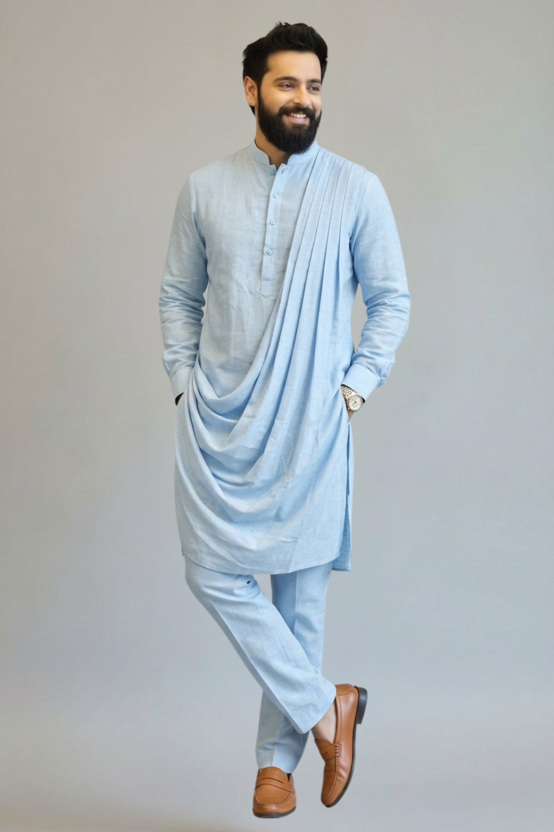 Man wearing a light blue kurta with a drape on a gray background