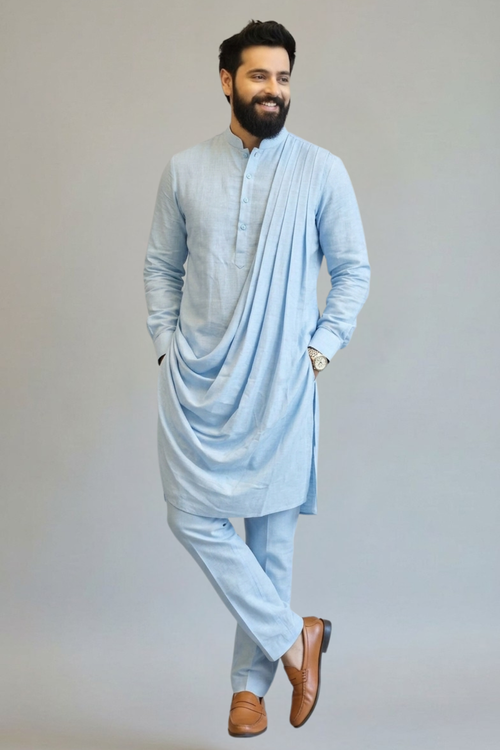 Man wearing a light blue kurta with a drape on a gray background
