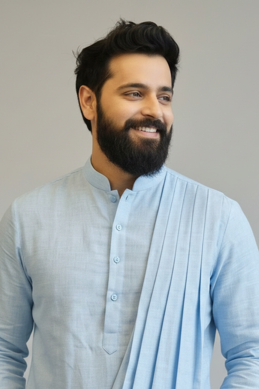 Man wearing a light blue kurta with a plain background