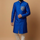 Man wearing a blue traditional coat with a tiger emblem on a beige background