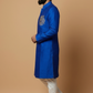 Man wearing a blue kurta with white pants on a beige background