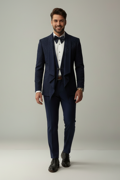 Man wearing a navy suit with a white shirt and black bow tie on a plain background