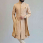 Man wearing a traditional beige sherwani with a turban on a light gray background
