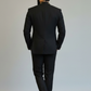 Man wearing a black suit against a plain background
