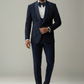 Man wearing a navy blue suit with a white shirt and black bow tie on a plain background