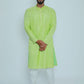 Man wearing a bright green kurta with white pants on a light gray background
