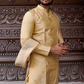 Man wearing a traditional beige kurta with intricate carvings in the background