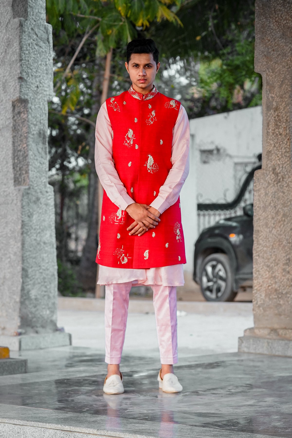 Men’s orange embroidered Indo-Western kurta set with pastel pink pants and white loafers for traditional ethnic wear styling