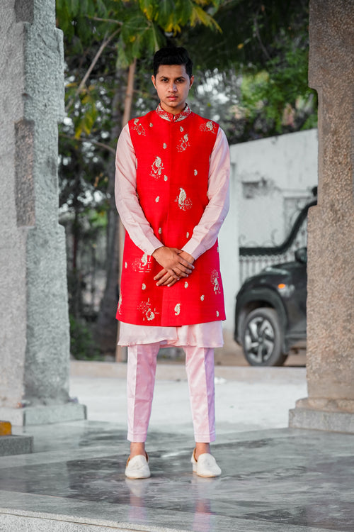 Men’s orange embroidered Indo-Western kurta set with pastel pink pants and white loafers for traditional ethnic wear styling
