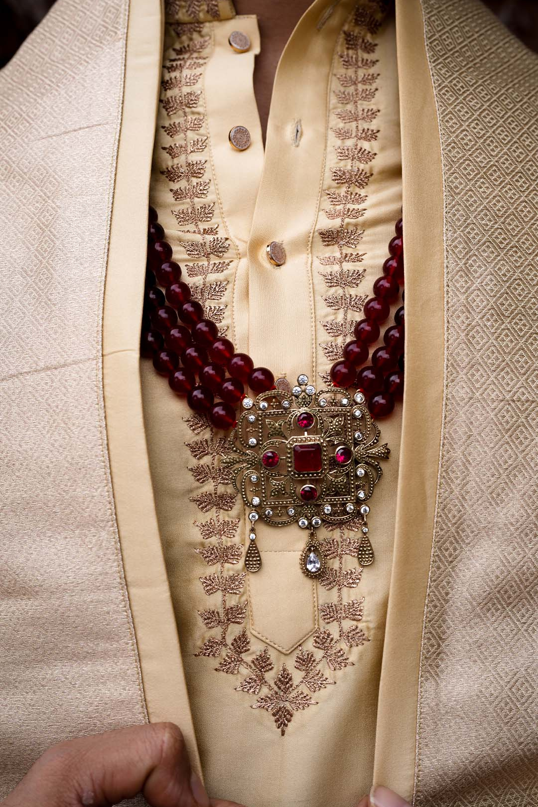 Close-up of a traditional embroidered garment with a necklace.