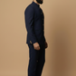 Man wearing a navy blue suit against a beige background