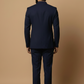 Man wearing a navy blue suit against a beige background