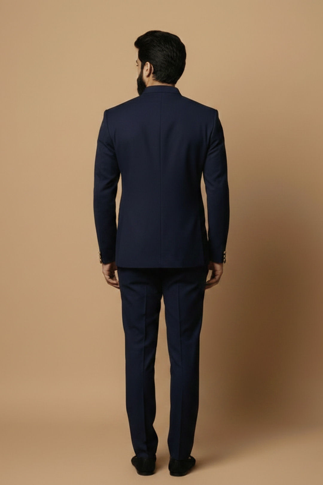 Man wearing a navy blue suit against a beige background