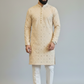 Man wearing a beige kurta with white pants on a plain background