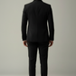 Man wearing a black suit against a plain background