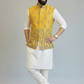 Man wearing a yellow embroidered vest over a white kurta with white pants on a gray background