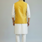 Man wearing a yellow embroidered vest over a white kurta with white pants on a gray background