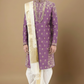 Man wearing a traditional purple and white sherwani with a beige stole on a brown background