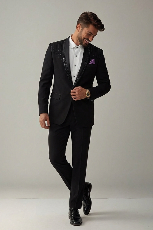 Man wearing a black suit with a white shirt and purple pocket square on a plain background