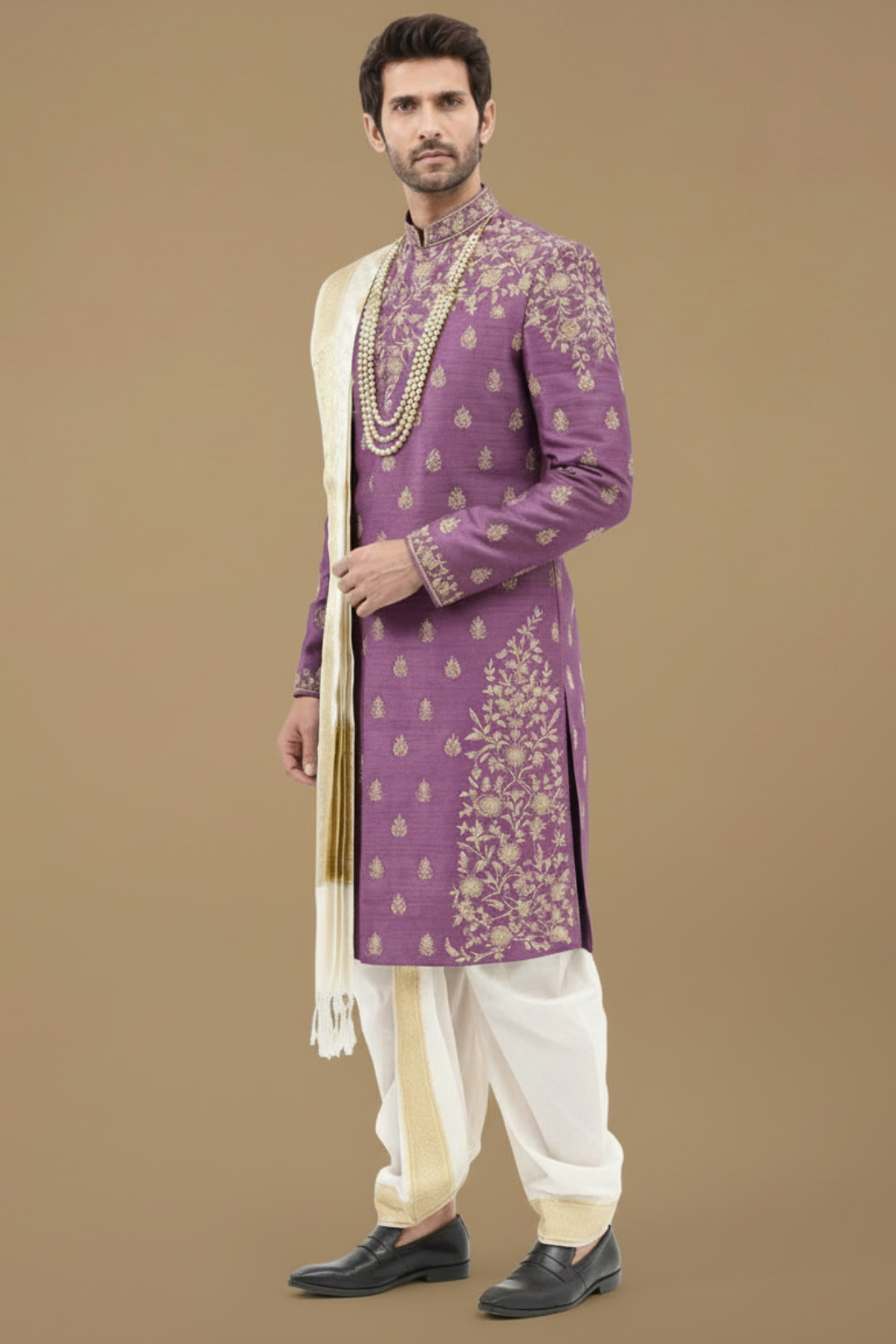 Man wearing a purple embroidered sherwani with a white stole against a beige background