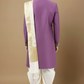 Man wearing a purple embroidered sherwani with a white stole against a beige background